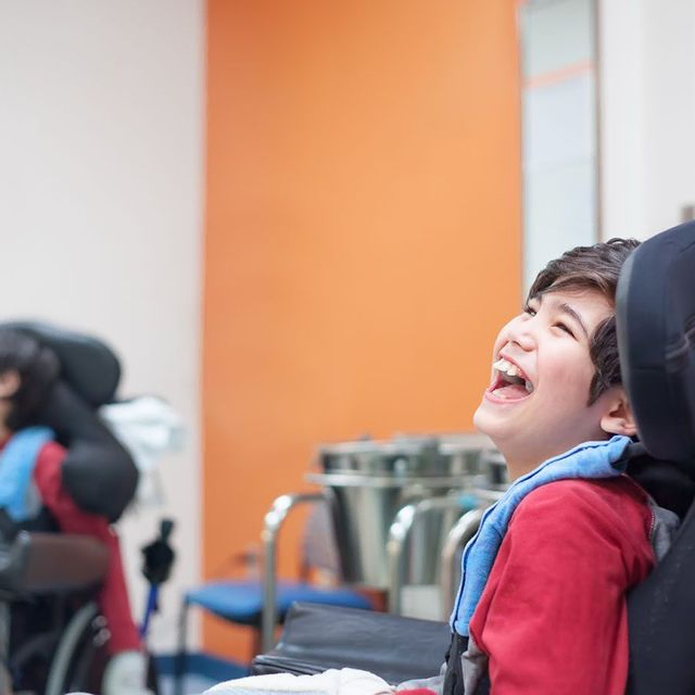 A joyful moment captured between a boy in a wheelchair and his friend.