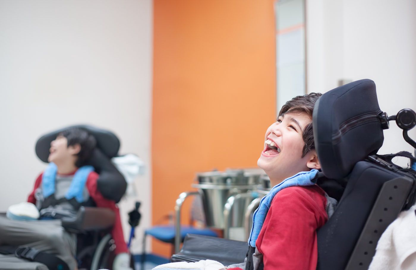 A joyful moment captured between a boy in a wheelchair and his friend.