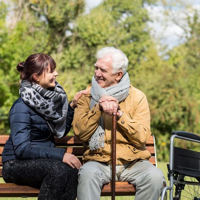 An elderly couple enjoying a serene moment together on a park bench, surrounded by nature's beauty.