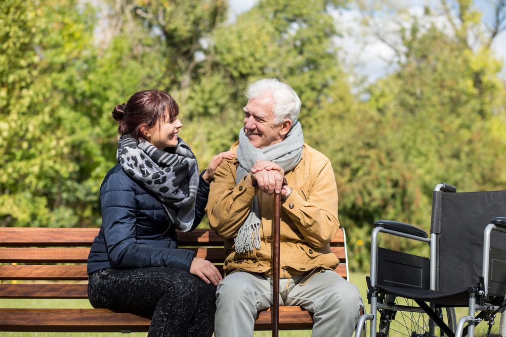 An elderly couple enjoying a serene moment together on a park bench, surrounded by nature's beauty.